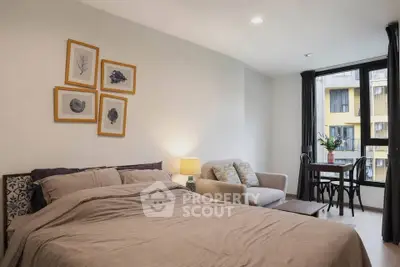 Cozy bedroom with modern decor and natural light, featuring a comfortable bed, stylish seating area, and dining nook.