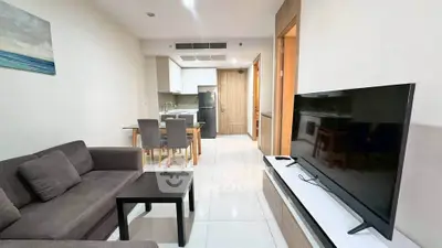 Modern living room with sleek furniture and open kitchen layout in a stylish apartment.