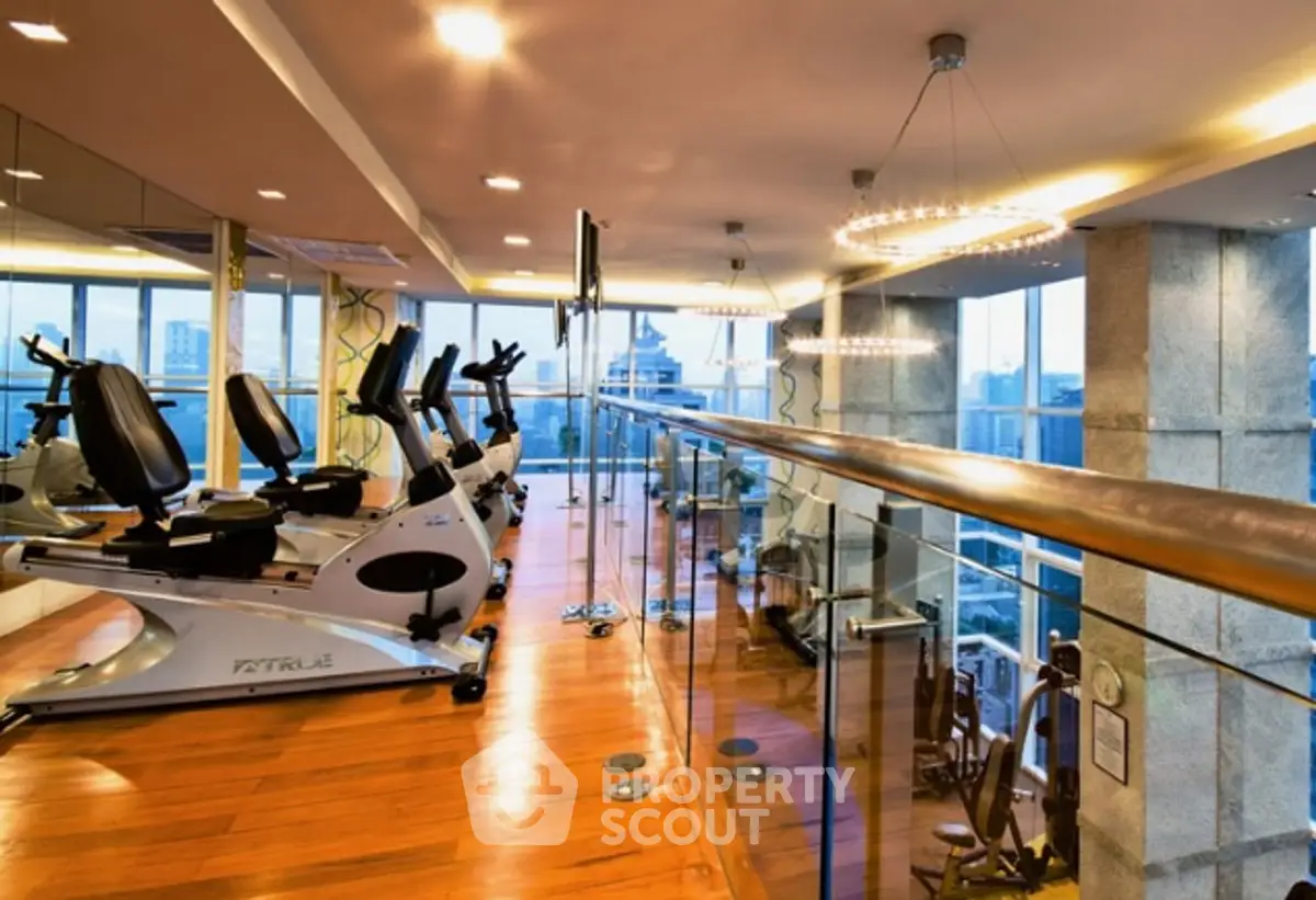 Luxurious high-rise gym with panoramic city views and modern fitness equipment.