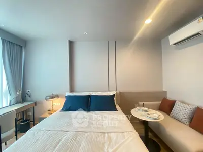 Modern bedroom with cozy seating area and natural light
