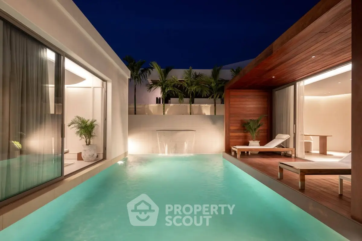 Luxurious modern villa with private pool and elegant patio at night.