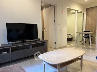 Modern living room with sleek furniture and TV, showcasing a cozy and inviting atmosphere.