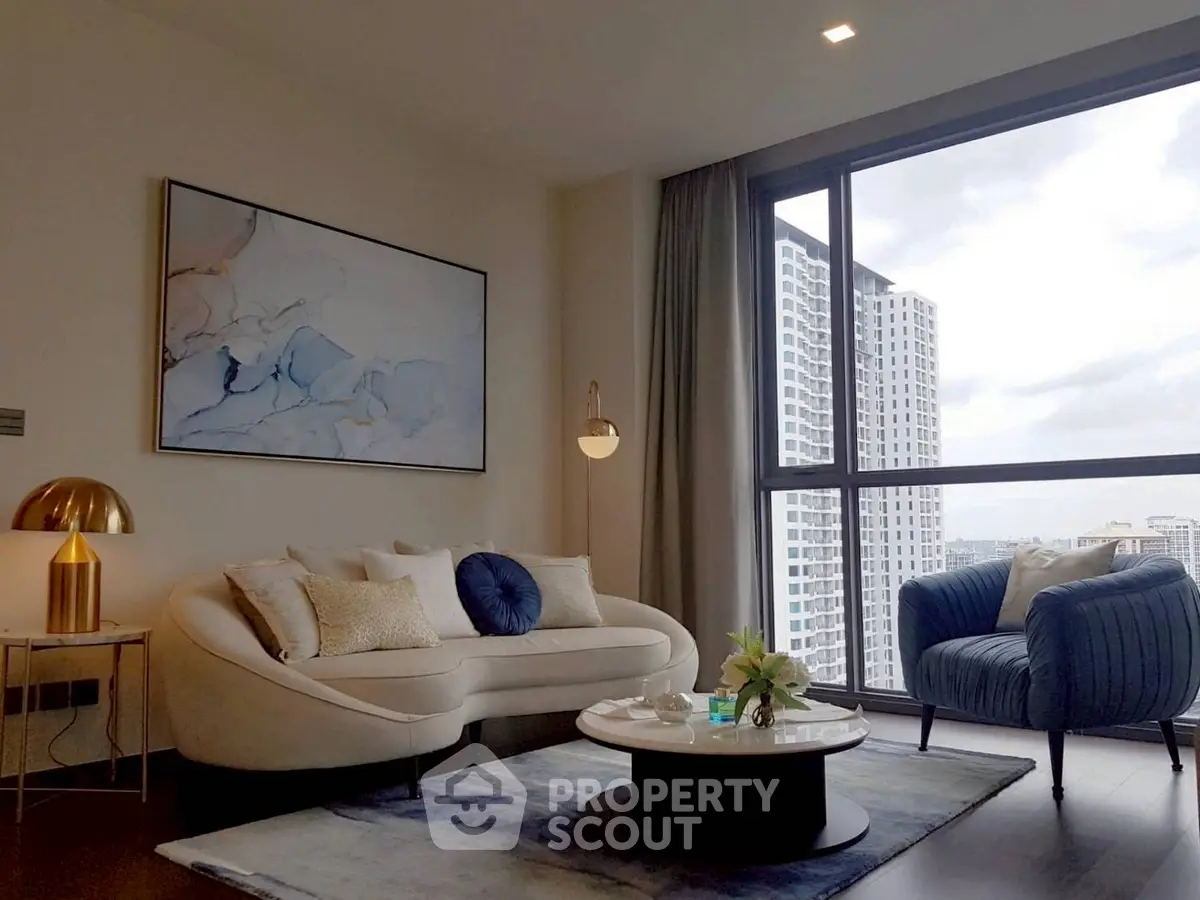 Modern living room with stylish furniture and large window offering city view.
