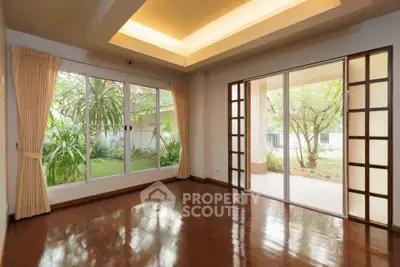 Spacious living room with hardwood floors and garden view in modern home