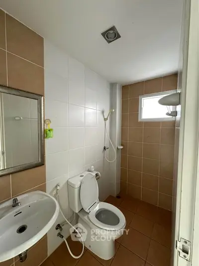 Compact bathroom with modern fixtures and neutral tiles