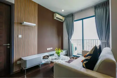 Modern living room with balcony view, featuring sleek furniture and stylish decor.
