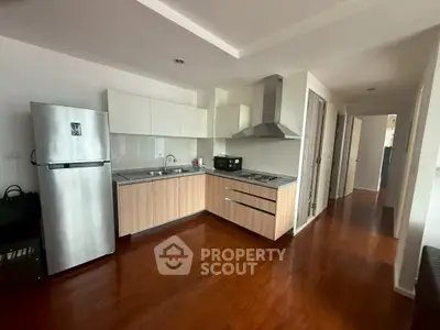 Modern kitchen with sleek cabinetry and stainless steel appliances in a spacious apartment.