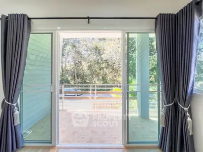 Spacious balcony with sliding glass doors and lush greenery view