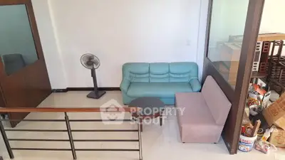 Cozy living area with modern furniture and fan in a bright room