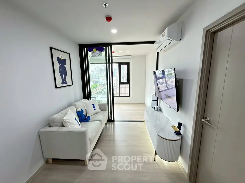Modern living room with stylish decor and city view, featuring a cozy sofa and wall-mounted TV.