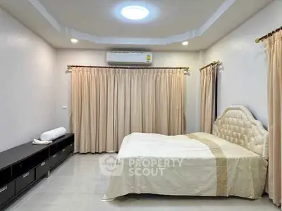 Spacious bedroom with elegant decor and ample natural light