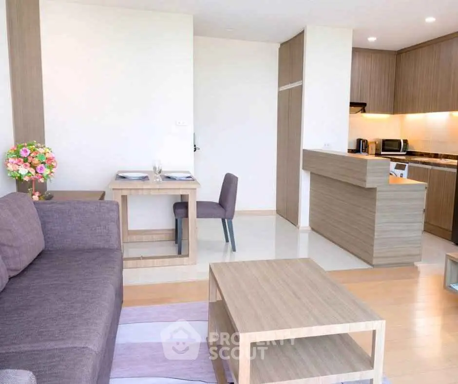 Modern open-plan living room and kitchen with stylish wooden furniture and cozy ambiance.