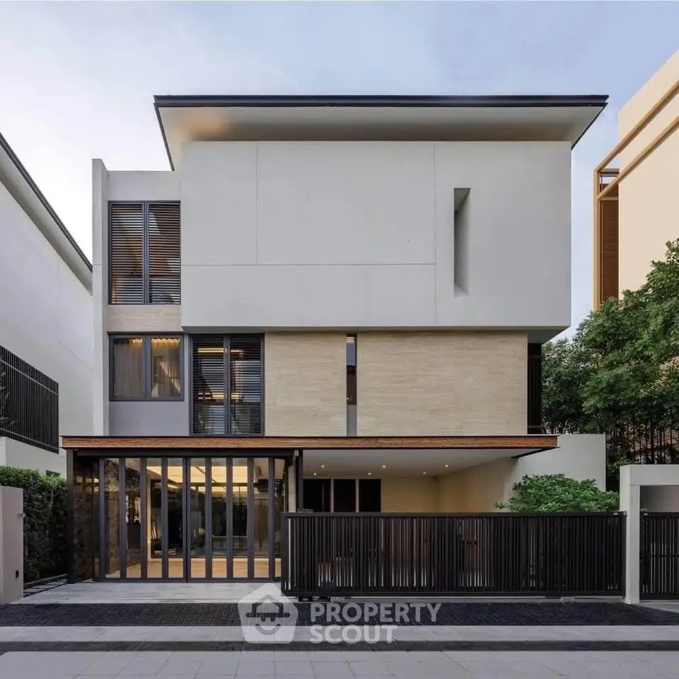 Modern three-story house with sleek design and large windows in a serene neighborhood.