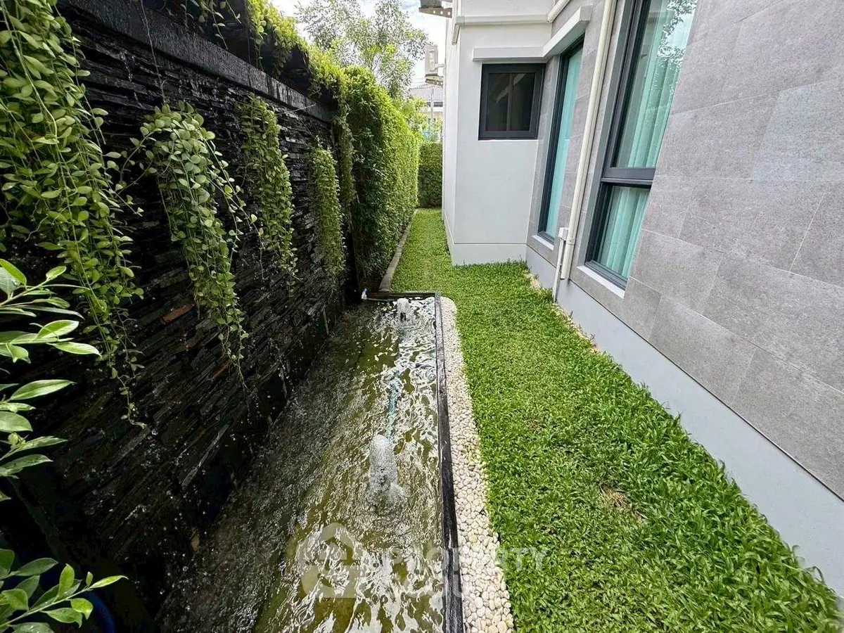 Charming garden with water feature beside modern home exterior