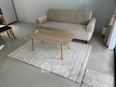 Modern living room with beige sofa and wooden coffee table on a light rug.