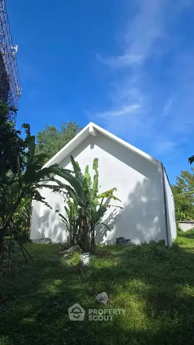 Charming white house with lush greenery and clear blue sky