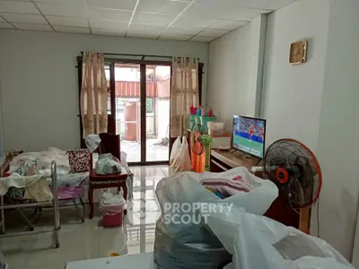 Cozy living room with TV and balcony access, ideal for relaxation and entertainment.