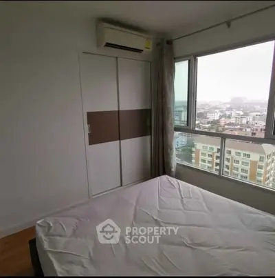 Spacious bedroom with city view and large window in modern apartment
