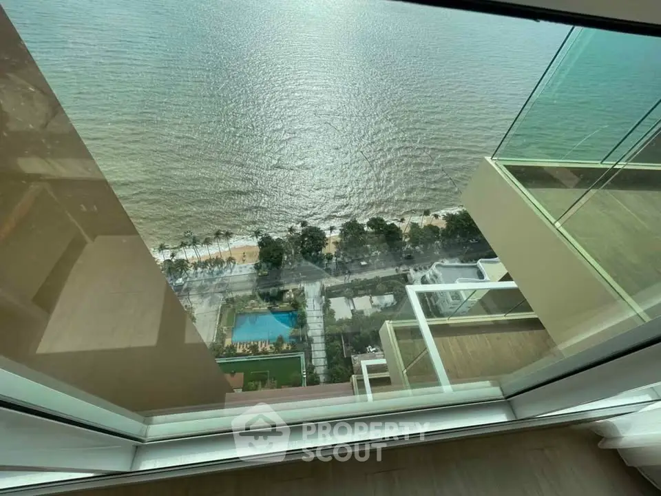 Stunning high-rise view of ocean and cityscape from a modern apartment balcony.