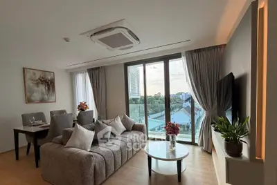 Modern living room with large windows and stylish decor in a high-rise apartment.