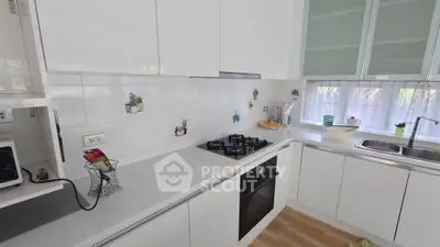 Modern kitchen with sleek white cabinets and built-in gas stove and oven