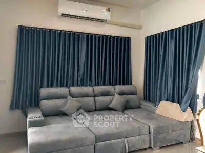 Modern living room with stylish grey sofa and elegant curtains