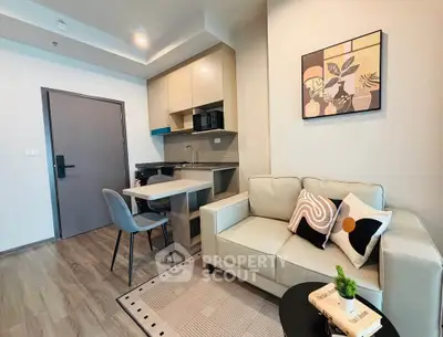 Modern living room with stylish decor and compact kitchen in open layout apartment.