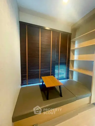 Cozy study nook with built-in seating and wooden shelves, perfect for reading or relaxation.