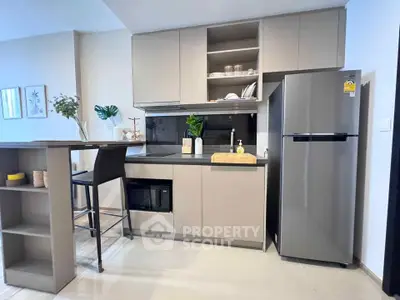 Modern kitchen with sleek cabinetry and stainless steel appliances in a stylish apartment.