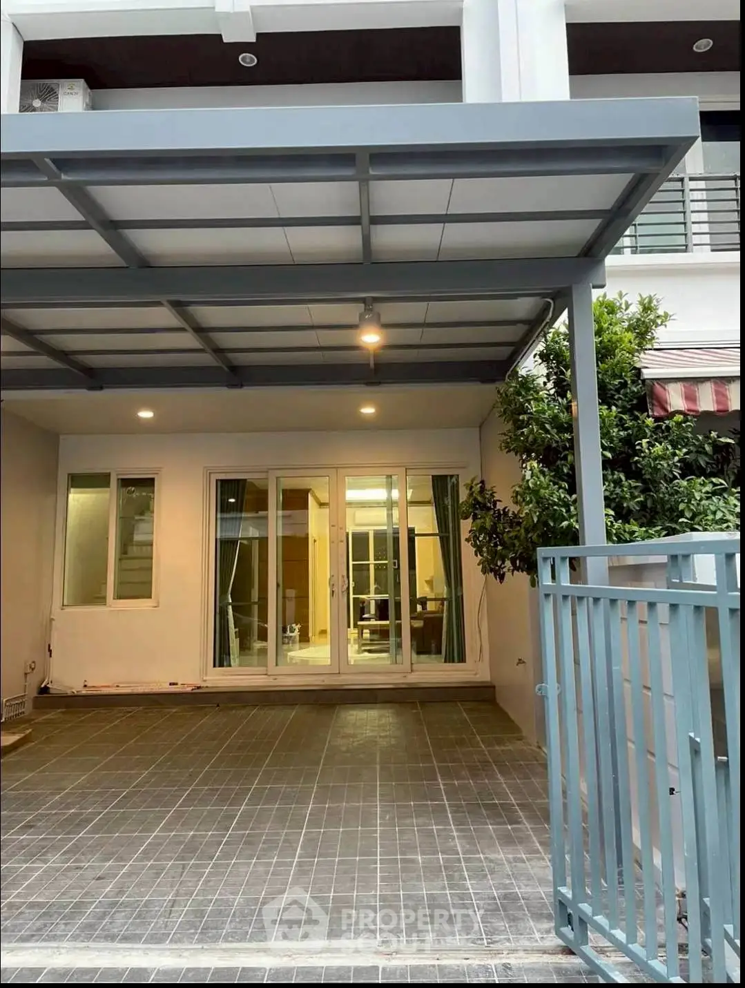 Modern townhouse with covered parking and glass sliding doors leading to interior.