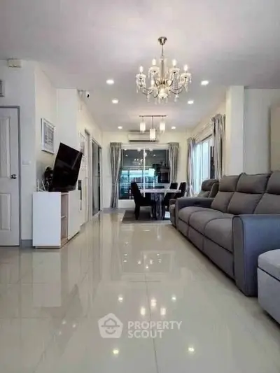 Spacious modern living room with elegant chandelier and sleek furniture