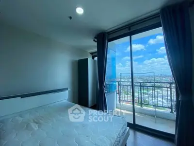 Bright bedroom with balcony offering stunning city views and ample natural light.