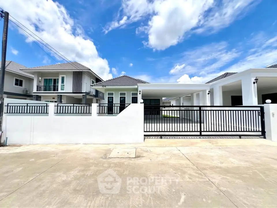 Modern suburban house with gated driveway and clear blue sky