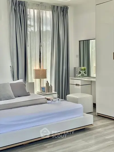 Modern bedroom with sleek design, featuring a stylish bed, elegant curtains, and a chic vanity area.