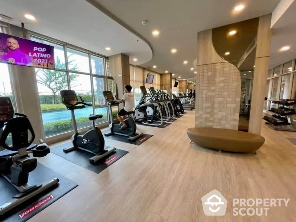 Modern gym with exercise equipment and large windows in luxury real estate property.