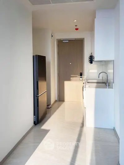 Modern minimalist kitchen with sleek appliances and ample natural light