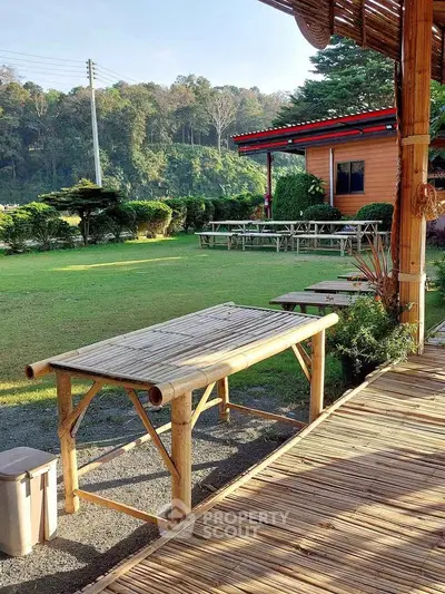 Charming outdoor area with bamboo furniture and lush greenery, perfect for relaxation and gatherings.