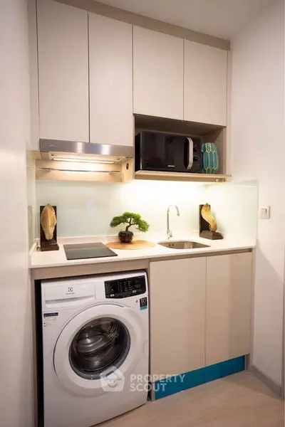 Modern compact kitchen with washing machine and sleek cabinetry