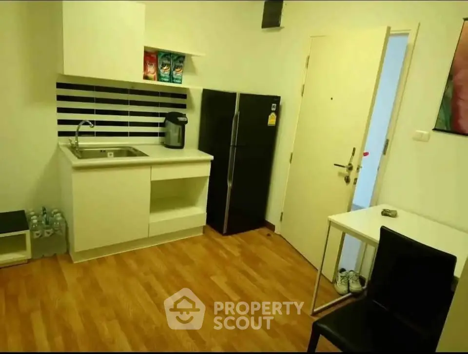 Modern kitchen with sleek black fridge and compact dining area