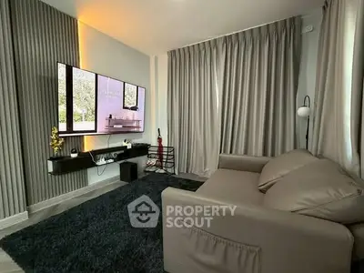 Modern living room with sleek design and large TV, perfect for relaxation.