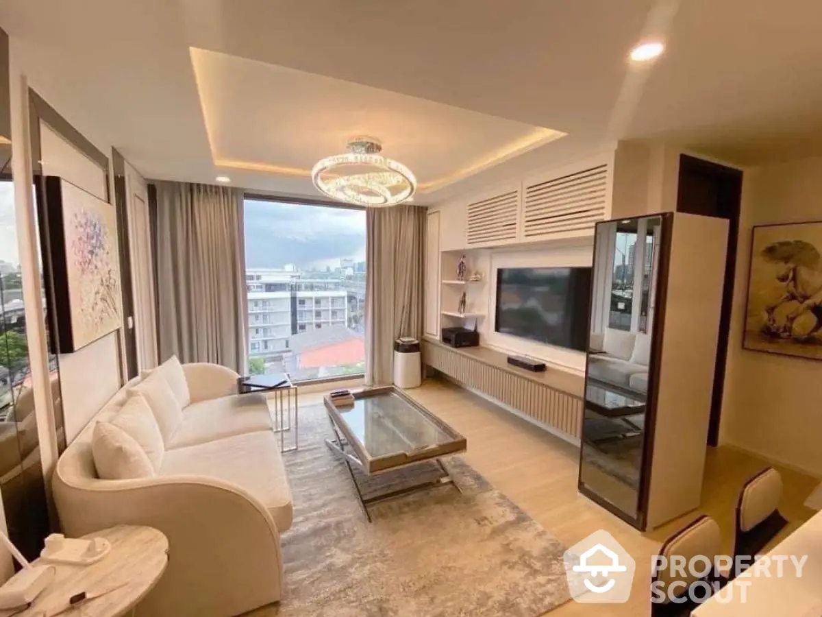 Modern living room with elegant decor and city view, featuring a cozy sofa and stylish chandelier.