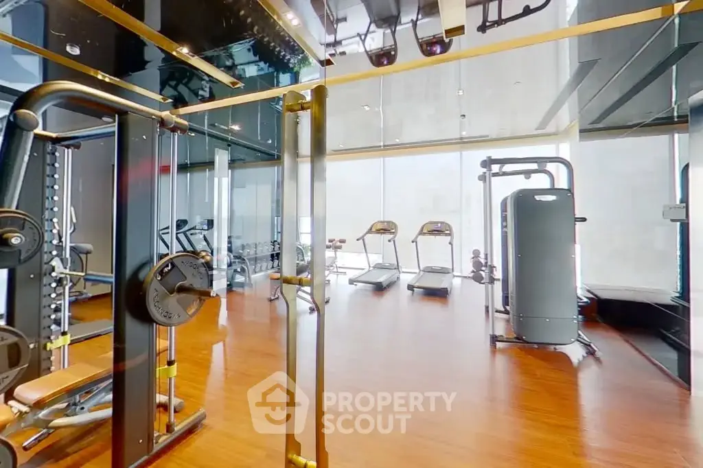 Modern gym with state-of-the-art equipment and sleek design in luxury building.