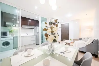 Modern open-plan living and dining area with sleek kitchen and cozy decor.