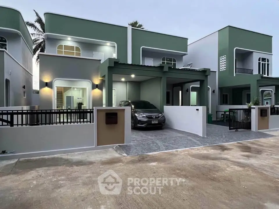 Modern duplex with sleek design, spacious driveway, and contemporary exterior lighting.