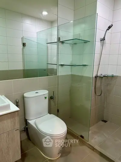 Modern bathroom with glass shower and sleek fixtures in a contemporary apartment.