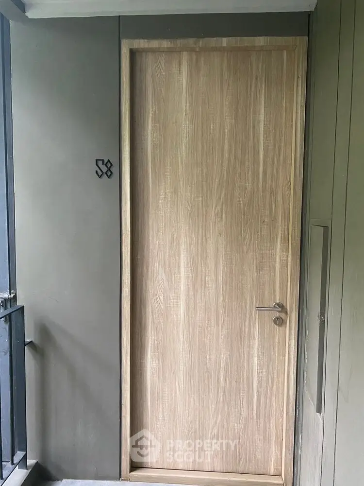 Modern apartment entrance with sleek wooden door and minimalist design.