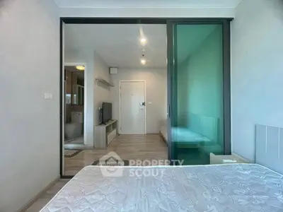 Modern bedroom with sliding glass door and view into living area