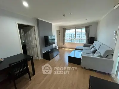 Spacious living room with modern furniture and large window offering natural light.