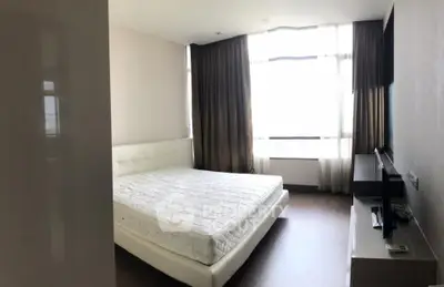 Spacious bedroom with large window and modern furnishings