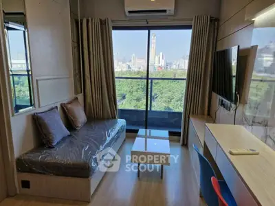Modern living room with city view, featuring sleek furniture and large window.